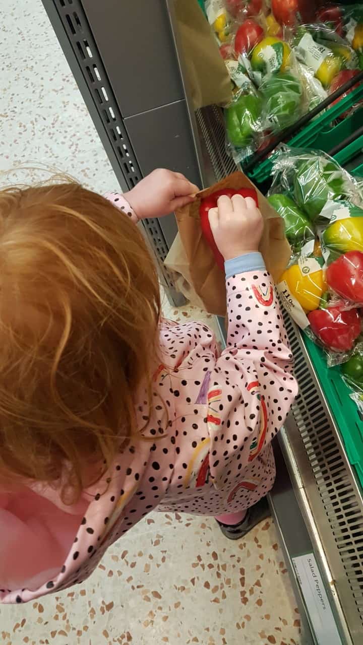 FCSS - young girl selecting peppers in a supermarket